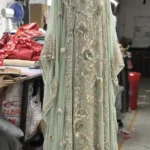 Mint green embroidered ethnic dress with intricate floral detailing and embellished borders displayed on a mannequin